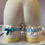 Thumbnail: Light blue and cream leg garter with a light blue bow and small white flower