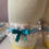 Thumbnail: Light blue and cream leg garter with a light blue bow and small white flower