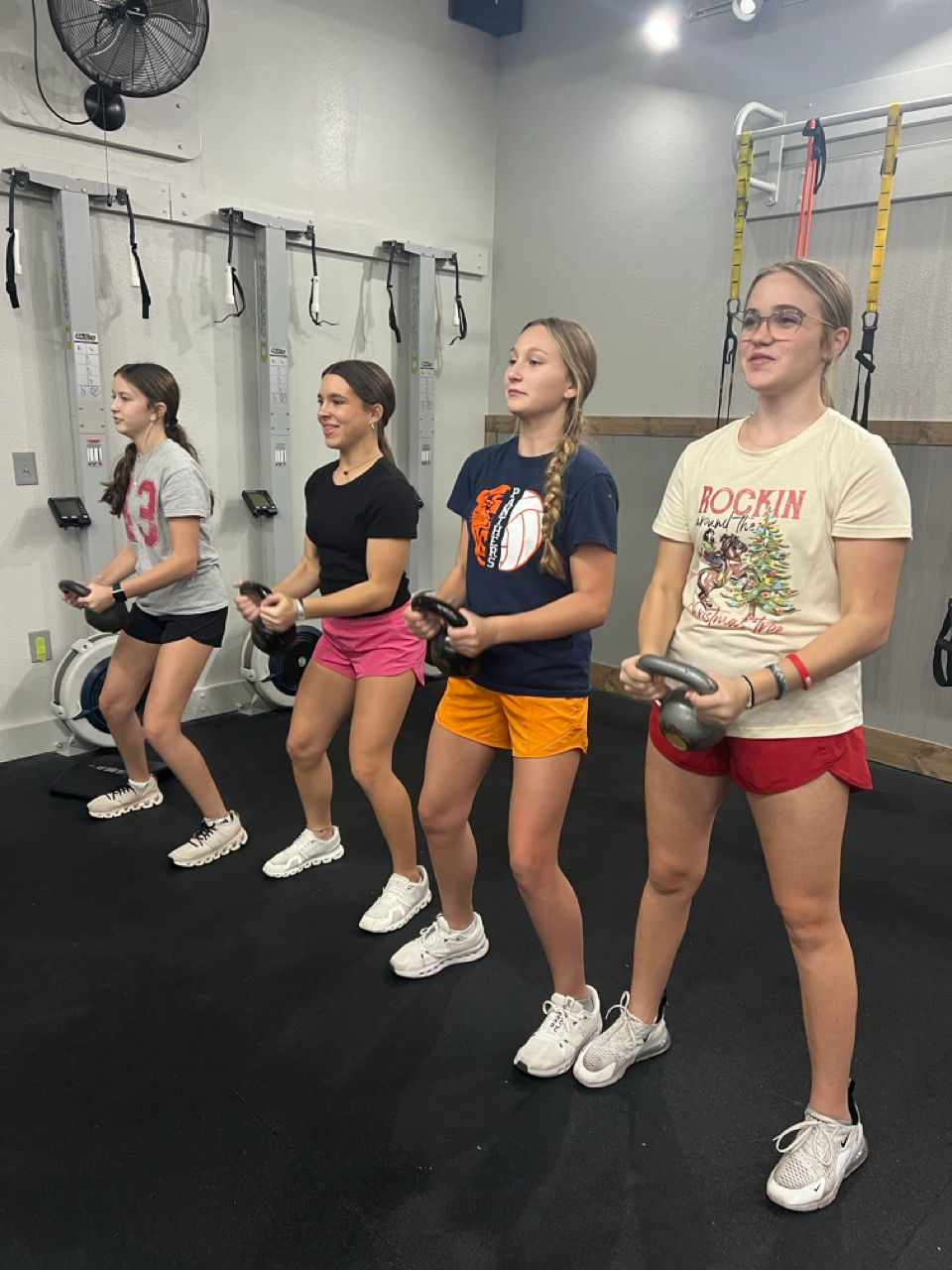 girl group performing weighted sqauts.jpeg