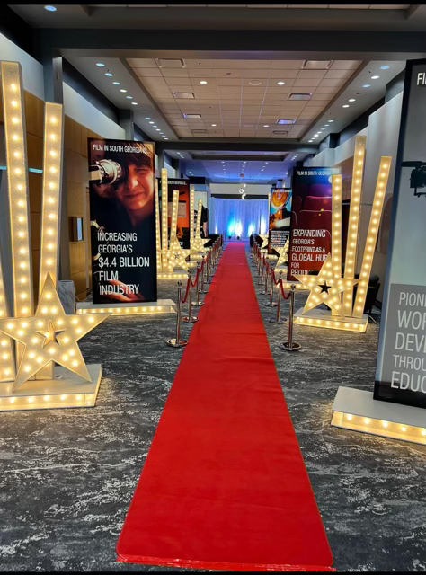 Movie premiere red carpet entrance with life size move posters.