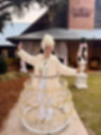 Unique interactive event entertainment featuring a performer in a custom champagne glass skirt at an extravagant outdoor party