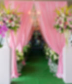 Entry way with green carpet, bouquets of flowers and pink drapery at a baby shower in Valdosta.