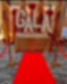 Extravagant red carpet entrance with large 'GALA' light-up marquee letters and gold stanchion velvet ropes.