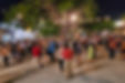 People dancing under string lights during a lively evening event at Parque de Santiago in Mérida, surrounded by trees and local vendors.