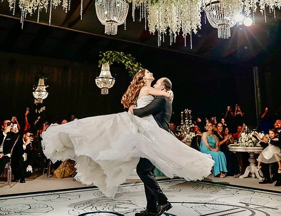 a Happy Couple smiling while performing a lift pose on their first dance at the reception