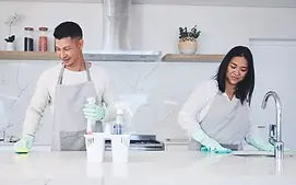 happy-couple-housekeeper-and-cleaning-table-in-ki-2025-04-06-07-27-00-utc.webp
