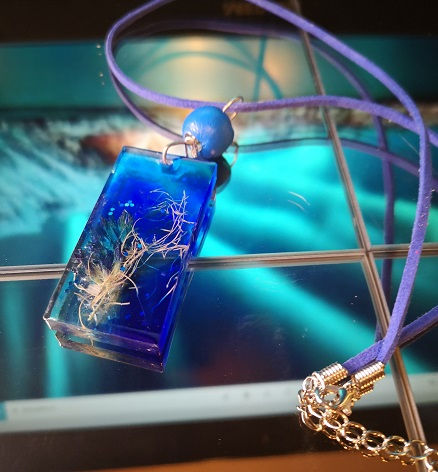 Blaues Halsband mit Epoxidharzanhänger und eingegossenen Pflanzenteilen