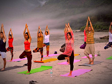 Yoga practitioner meditating by the Ganges River in Rishikesh, India, surrounded by Himalayan foothills