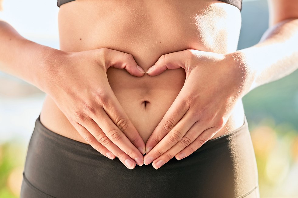 a woman making a heart over her belly with her hands