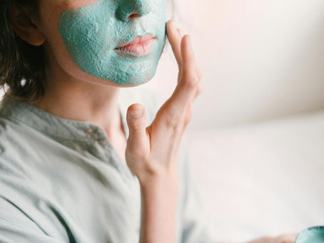 Client applying a calming facial mask as part of a professional skin treatment at Sycamore Medi Spa in Canberra