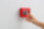 Woman using manual call point of fire alarm system.jpg