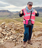 woman on to of a fell in pink vest