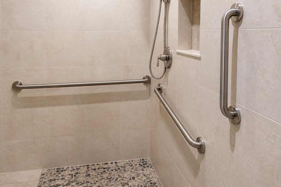 Close-up of stainless steel grab bars mounted securely on a ceramic tile shower wall with visible mounting hardware and proper spacing