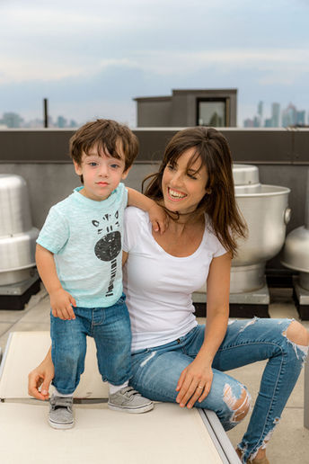 Mother sitting with her son on rooftop, hugging and smiling