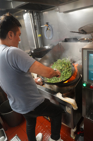 手持四斤多的大鑊炒菜,力道需均勻,火候必須恰到好處