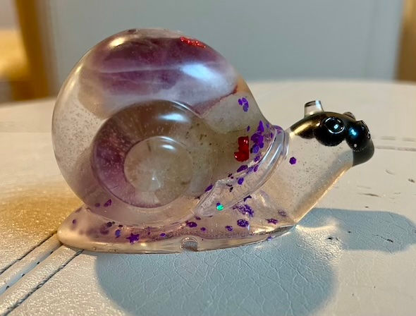 Snail decoration with purple coloring and white rock