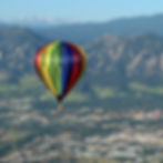 Hot Air Balloon Above City and Mountains Daytime