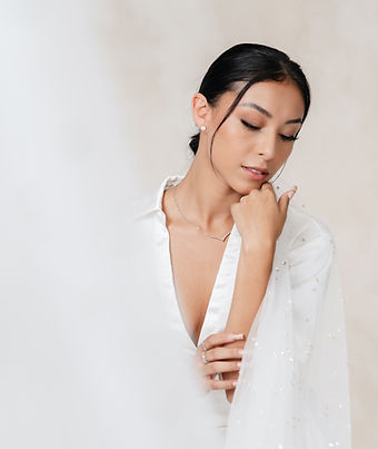 in studio bridal photoshoot. bride looking softly to the sidee with low bun updo