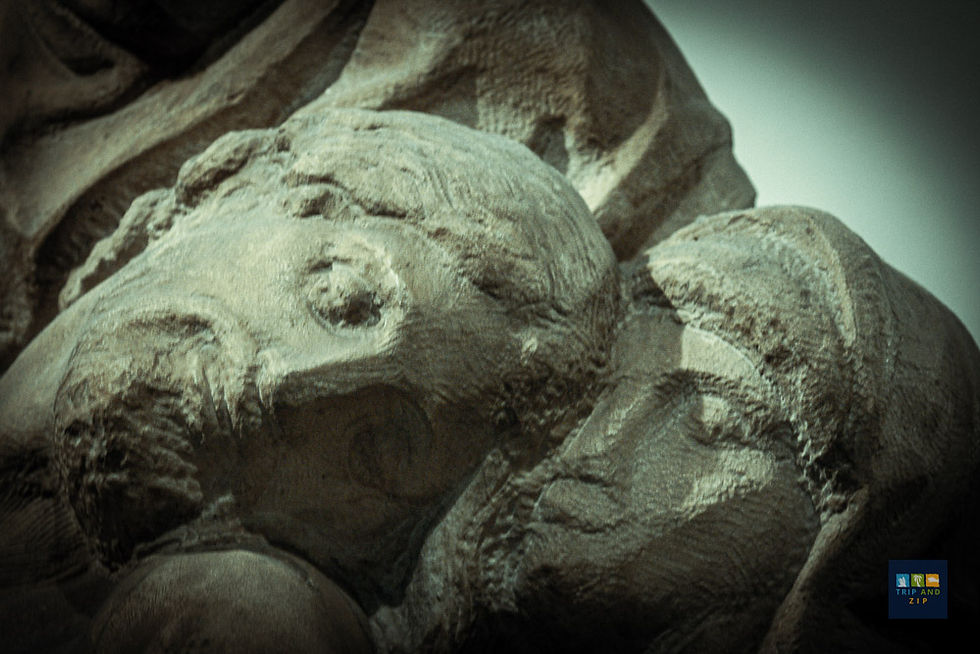 Stone sculpture of two figures embracing, conveying a serene mood.