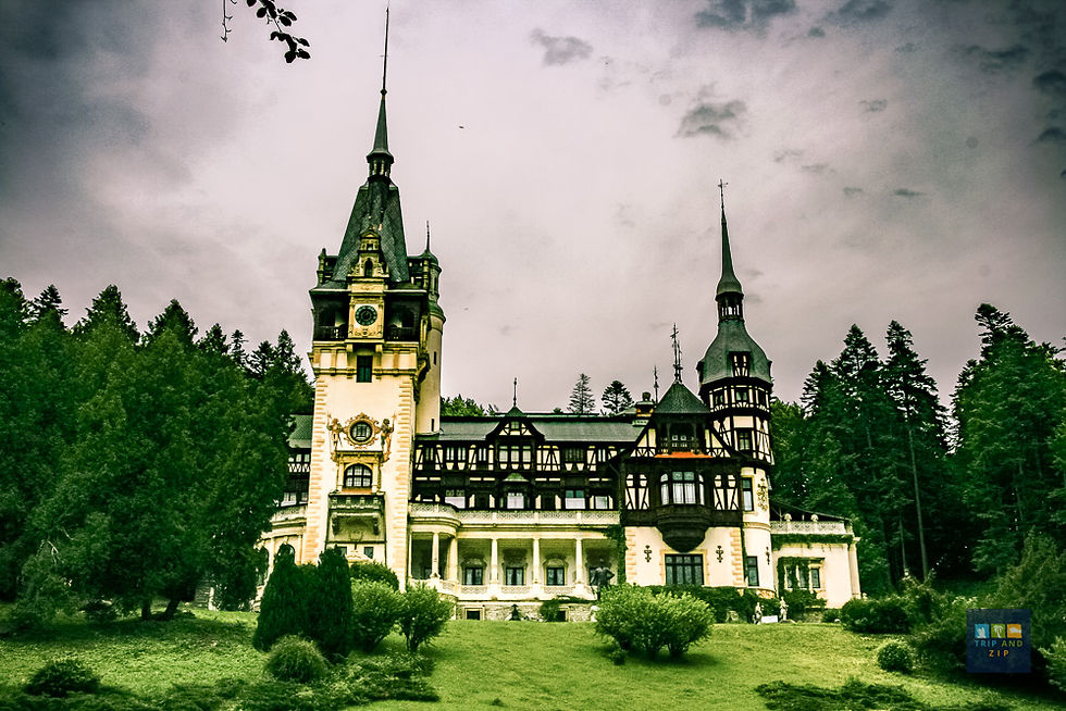 Gothic-style castle with spires set against a cloudy sky, surrounded by green trees and grass. Romantic, mysterious atmosphere.