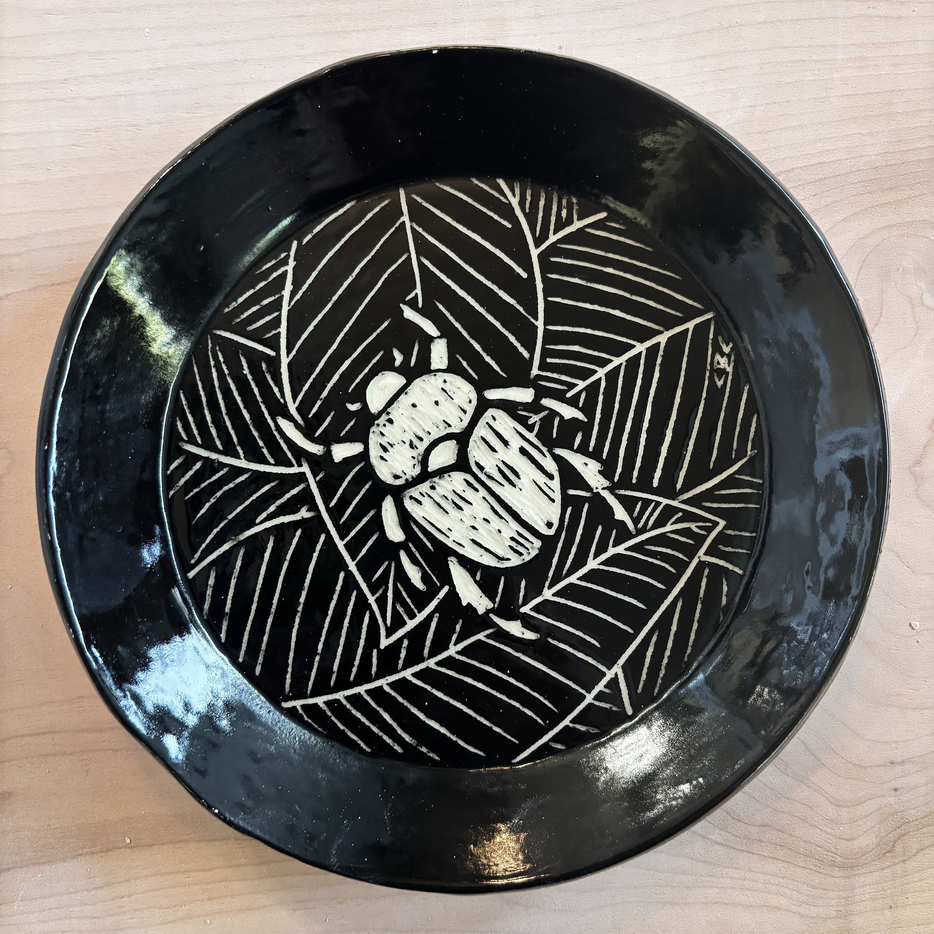 Black plate with white insect and leaf design, art Beginning Handbuilding, Monday Evenings Studio 2