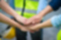 Group of engineers and workers join hands for teamwork in warehouse factory.jpg