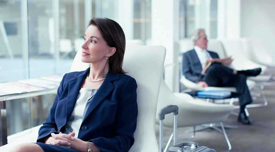 Businesswoman with suitcase waiting in airport