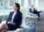 Businesswoman with suitcase waiting in airport