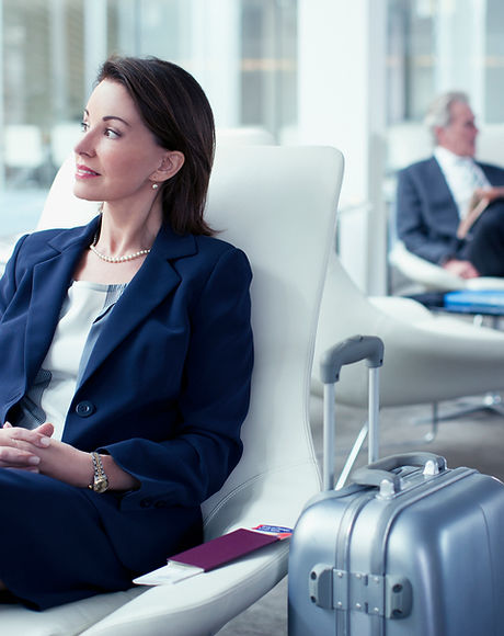 Businesswoman with suitcase waiting in airport