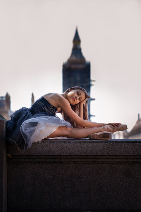 beautiful Portrait photography of a ballerina on point shoes sitting in front of Westminster
