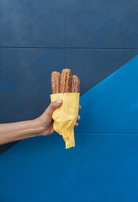close-up-person-holding-up-food-with-blue-background.jpg