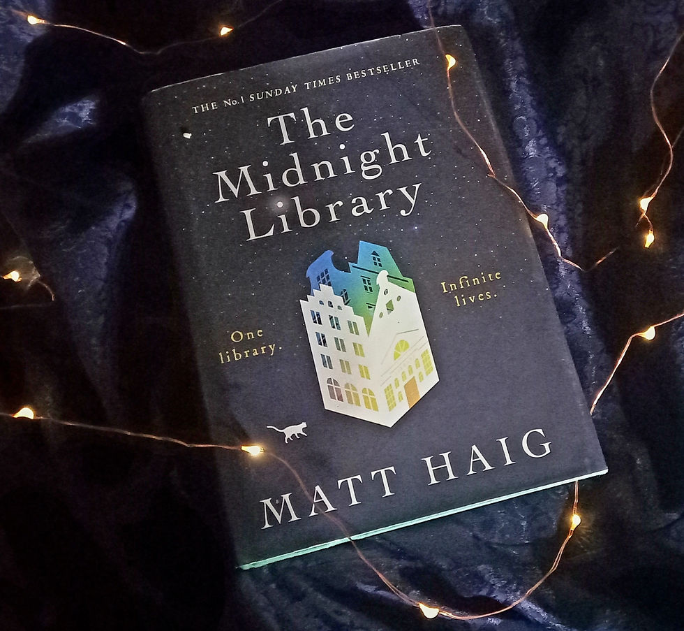 A copy of Matt Haig's The Midnight Library lies on a midnight blue cloth with its folds catching the light, making it glisten. A string of tiny twinkly lights is strewn around the book. Photo by Ninay Desai.