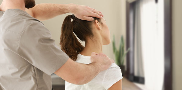 woman with neck pain being evaluated before receiving chiropractic care