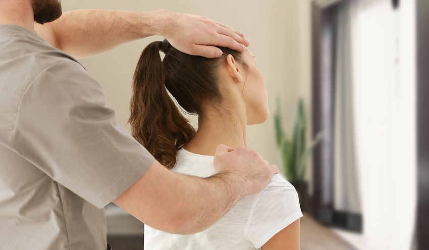 Chiropractor stretching patient's neck