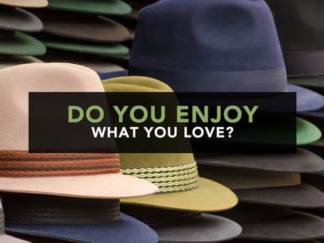 Rows of colourful hats representing the many roles of a creative business owner in the blog post do you enjoy what you love