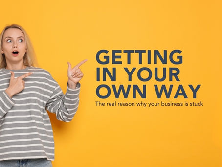 A young white woman with long blonde hair is pictured to the left of the image. She is stood in front of a yellow background and is wearing a blue an white stripey top. She is looking surprised and is pointing with both hands to her right to some words that read "Getting in your own way: the real reason your creative business is stuck."