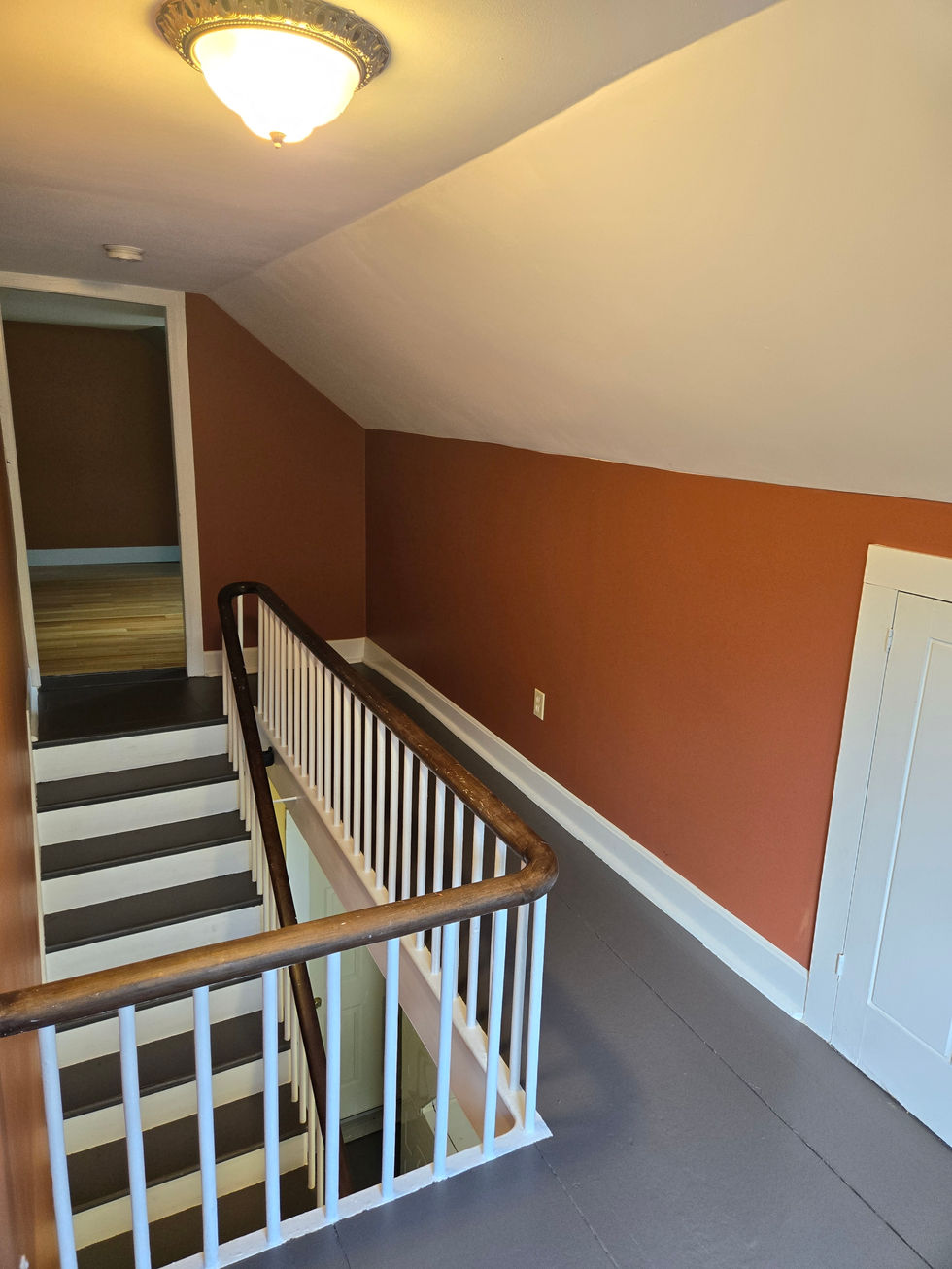 a staircase with red walls and a white railing