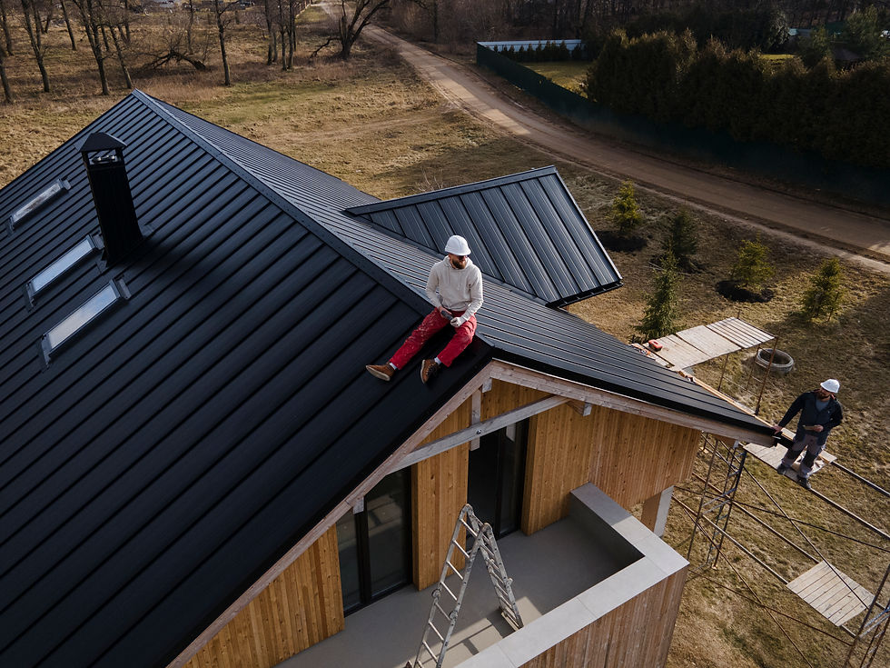 Um homem de capacete no telhado de uma residência em construção descansando