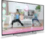 Best Yoga App for Free in 2026. Person and animated character performing Warrior 2 Pose in a living room. Screen shows "Exhale," "72 Accuracy," and "01:12." Cozy setting.