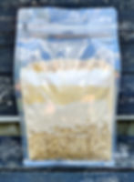 cornmeal, flour, oats, and cracked corn in a bag on a black bench