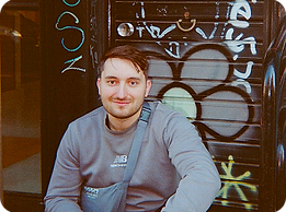 An image of Sorin smiling at the camera. He is smiling at the camera and sat in a doorway.