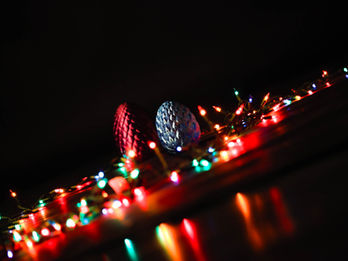 A pair of 3d printed dragon eggs surround by Christmas lights photographed at an angle