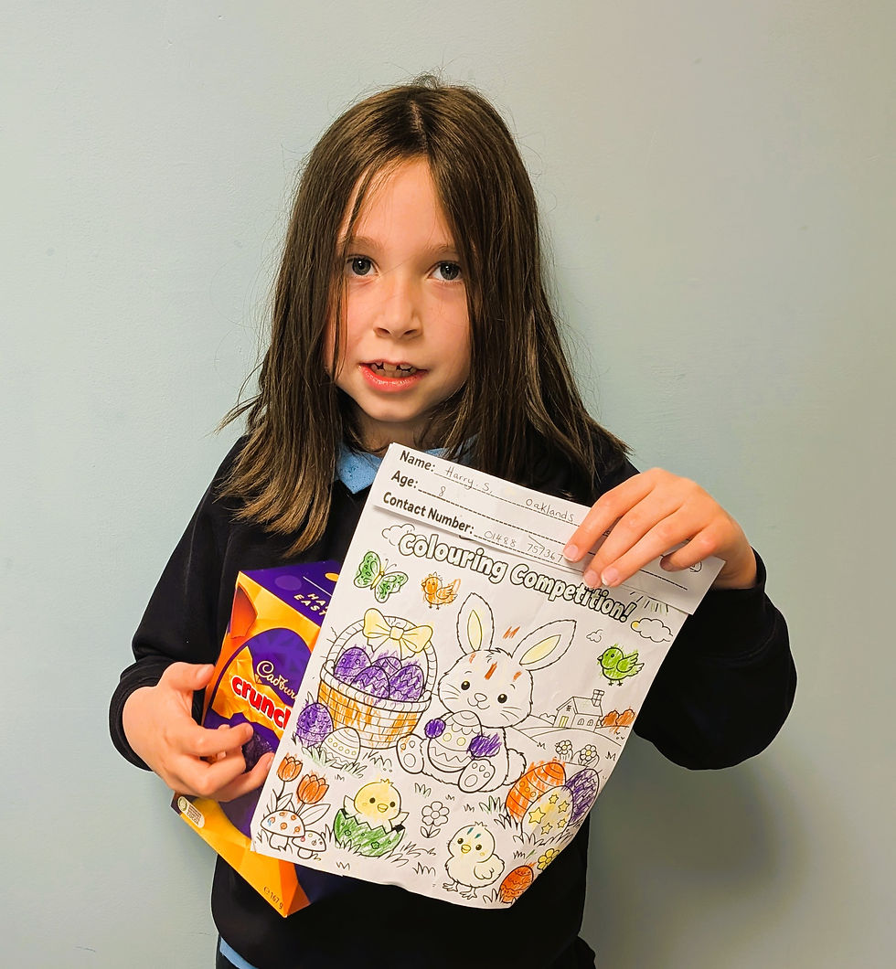 Harry holding his prize winning coloured-in Easter scene and his prize - an Easter egg