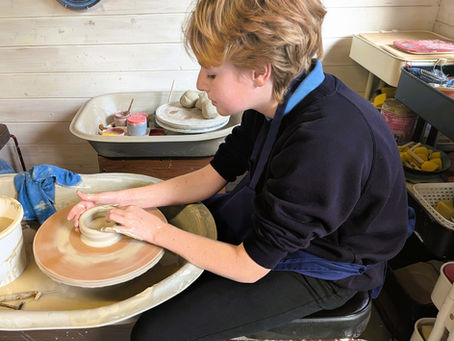 A pupil from Beech Class using a wheel to make a bowl out of clay