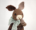 image of a brown knitted rabbit, with a polka-dotted fabric bow