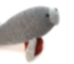 Knitted manatee toy shown from the side, with front flippers attached.