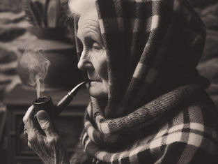 An elderly woman smokes a pipe in a croft to commune with spirits and ancestors
