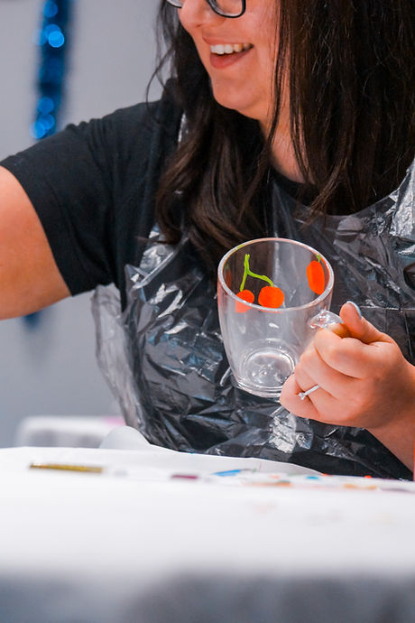 Woman in plastic apron holding a glass cup