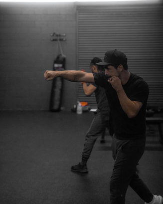 Paulie boxing trainer teaching his clients how to punch while improving balance and burning fat.