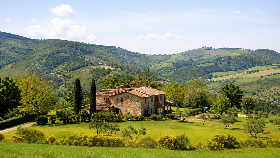 Vista panoramica di una casa in campagna con terreno verde e colline sullo sfondo